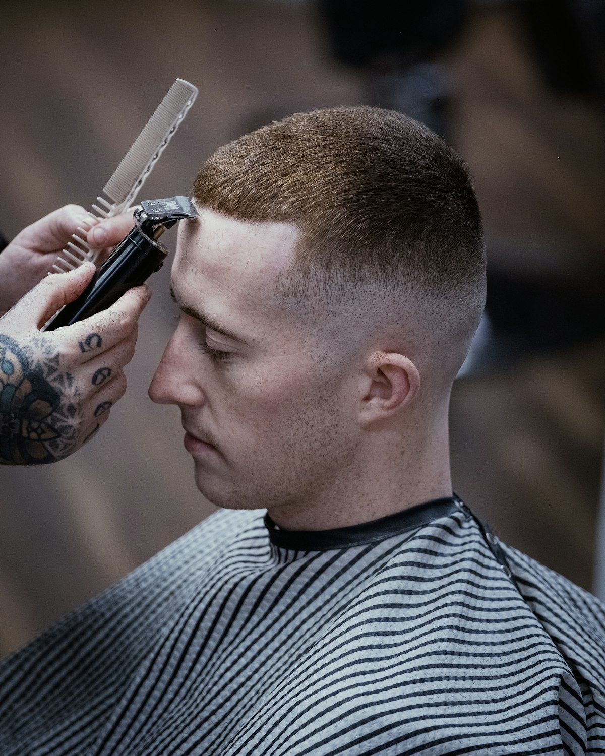 Barber running clippers up the side of a client's head during a skin fade