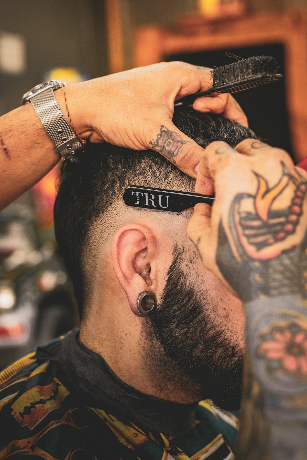 Close view of shaved line detail being cut into the back of a client's head with a straight razor