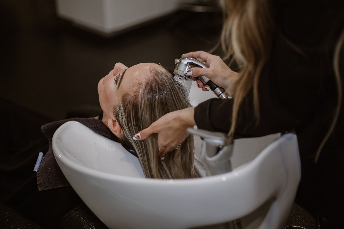 Colour being rinsed out of a client's hair at the studio basin